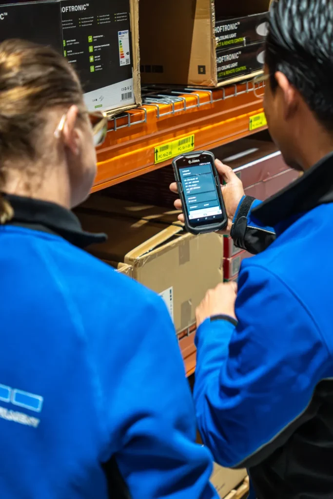 LSE medewerkers kijken naar handscanner